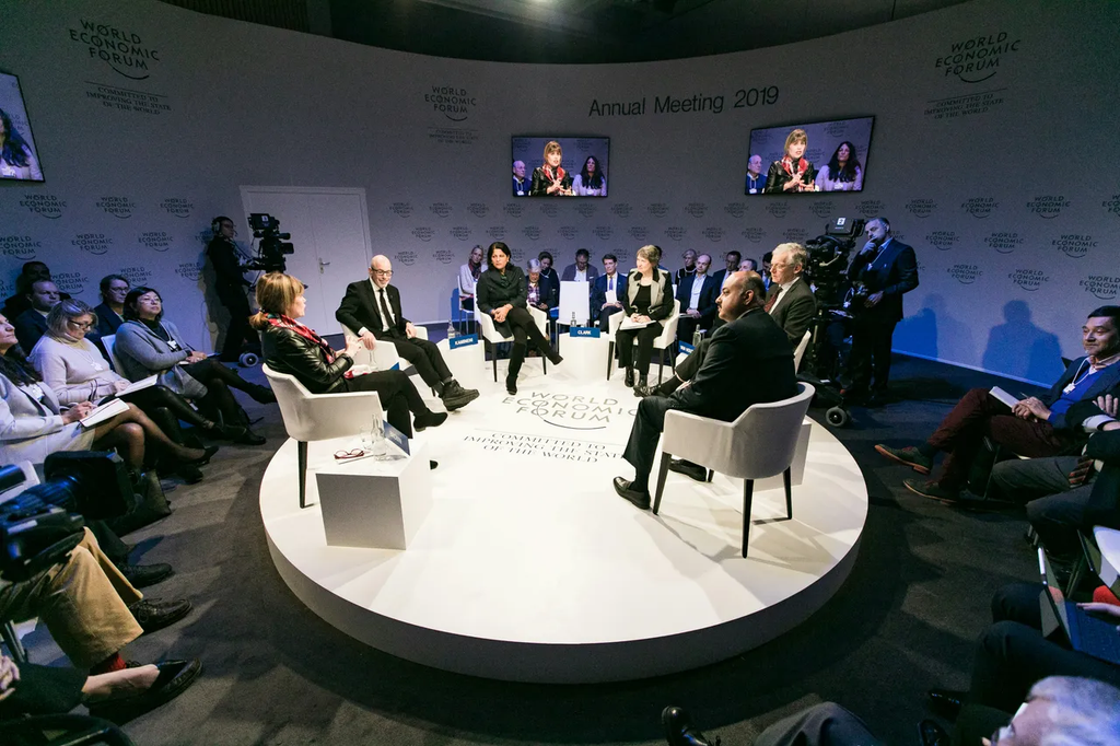 Round Stage with Panel Discussion at Conference with Step and Repeat Backdrop