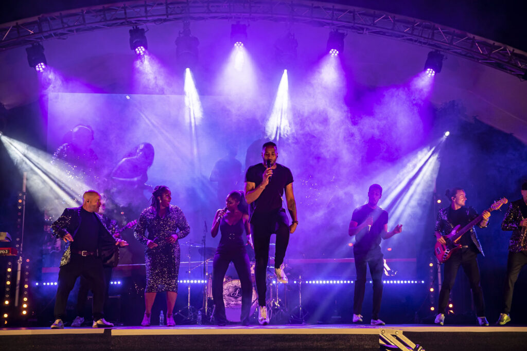 Band with LED wall behind, stage and Purple lighting for a festival
